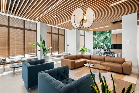 a living room with furniture a large window and a chandelier