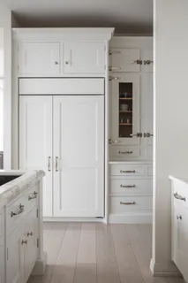 a white stove top oven sitting inside of white cabinets