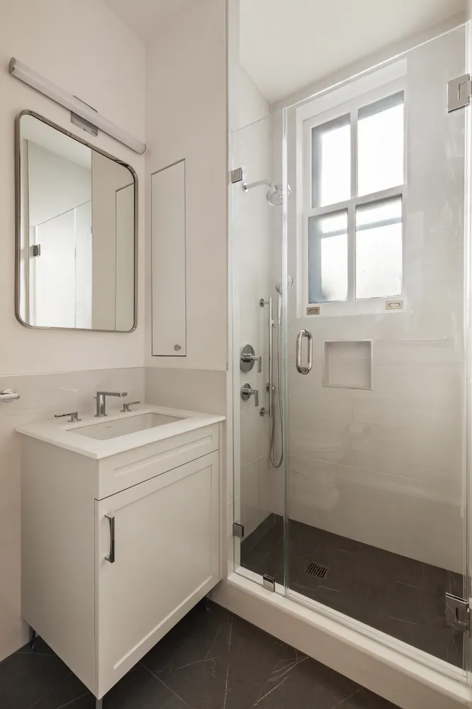 a bathroom with a sink a toilet and shower