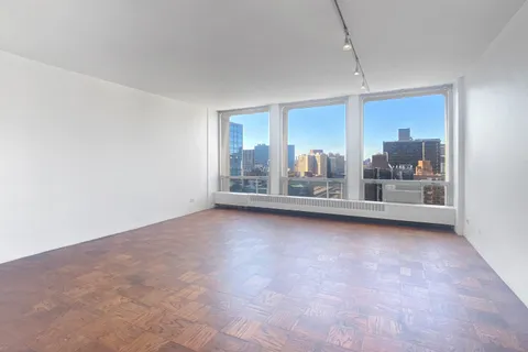 an empty room with floor to ceiling windows and outdoor view