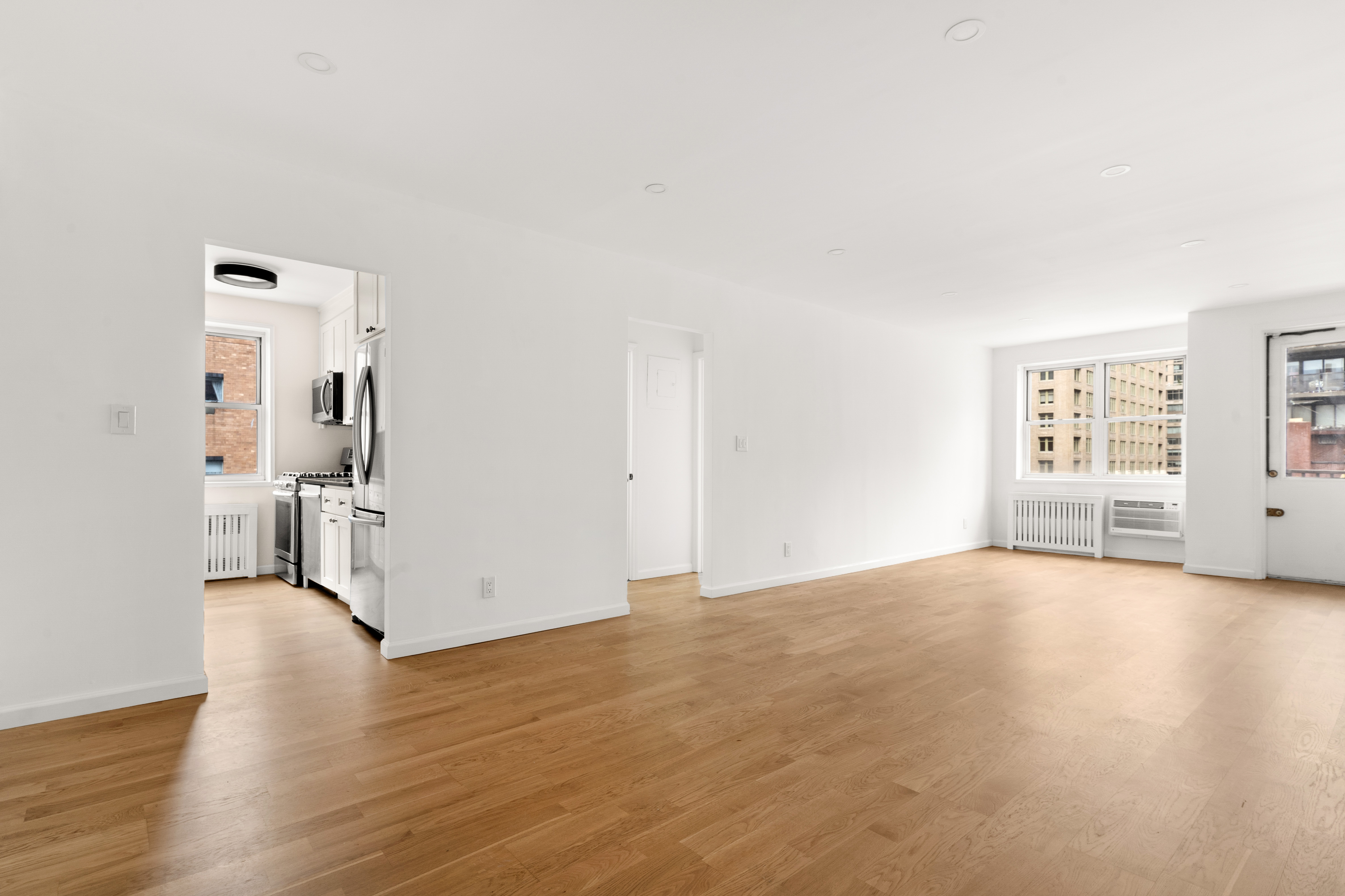 170 West 23rd Street, Unit 5N Manhattan, NY 10011 - Photo 4 of 17 a view of empty room with wooden floor and windows