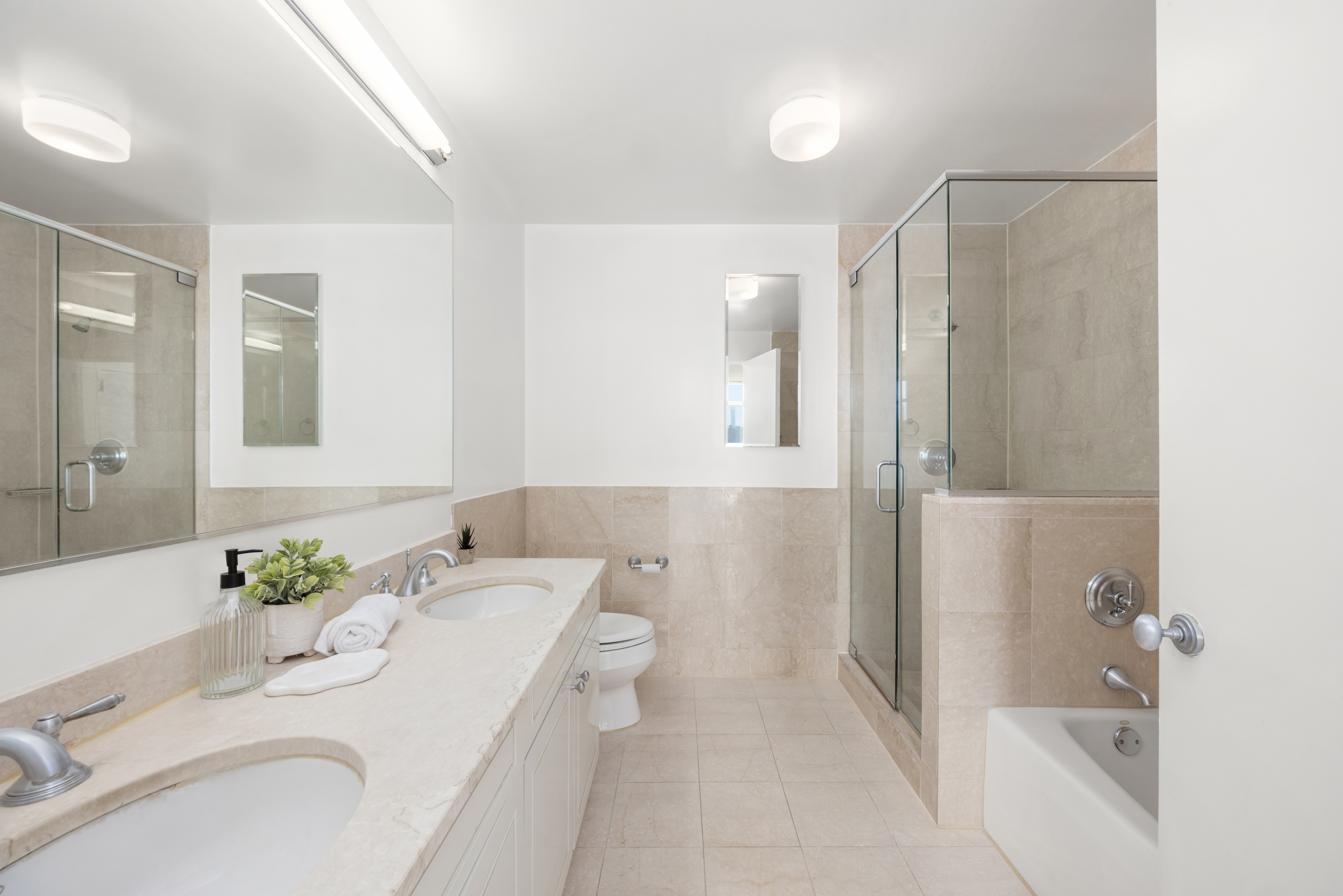 1760 2nd Avenue, Unit 30C Manhattan, NY 10128 - Photo 8 of 21 a bath room with a sink and a mirror