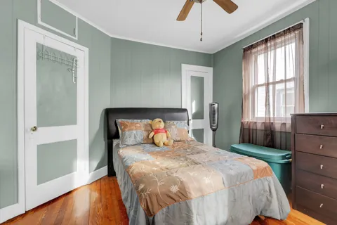 a bedroom with a bed and wooden floor