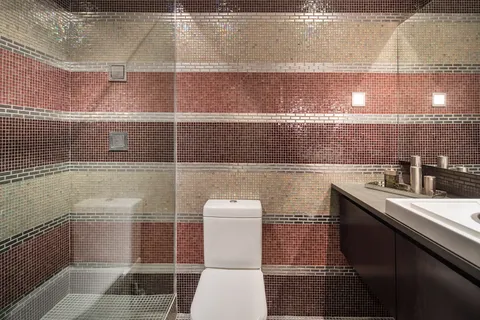 a bathroom with a toilet a sink and mirror