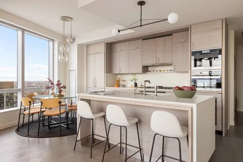 a kitchen with stainless steel appliances a dining table chairs and white cabinets