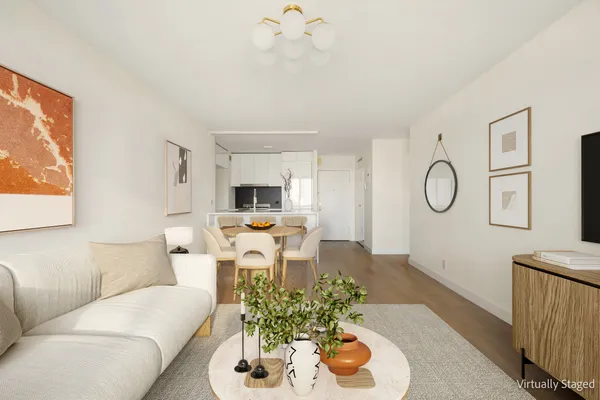 a living room with furniture kitchen view and a large window