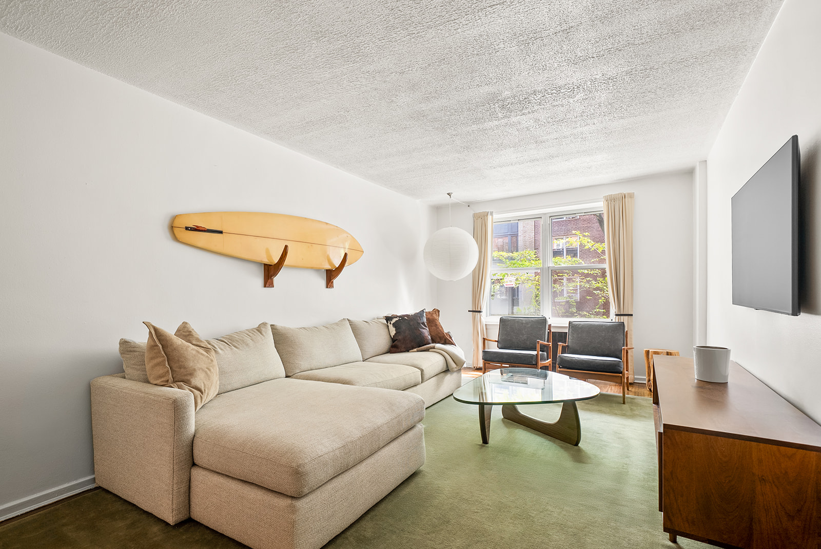 33-26 82nd Street, Unit 1H Queens, NY 11372 - Photo 1 of 11 a living room with furniture and a large window