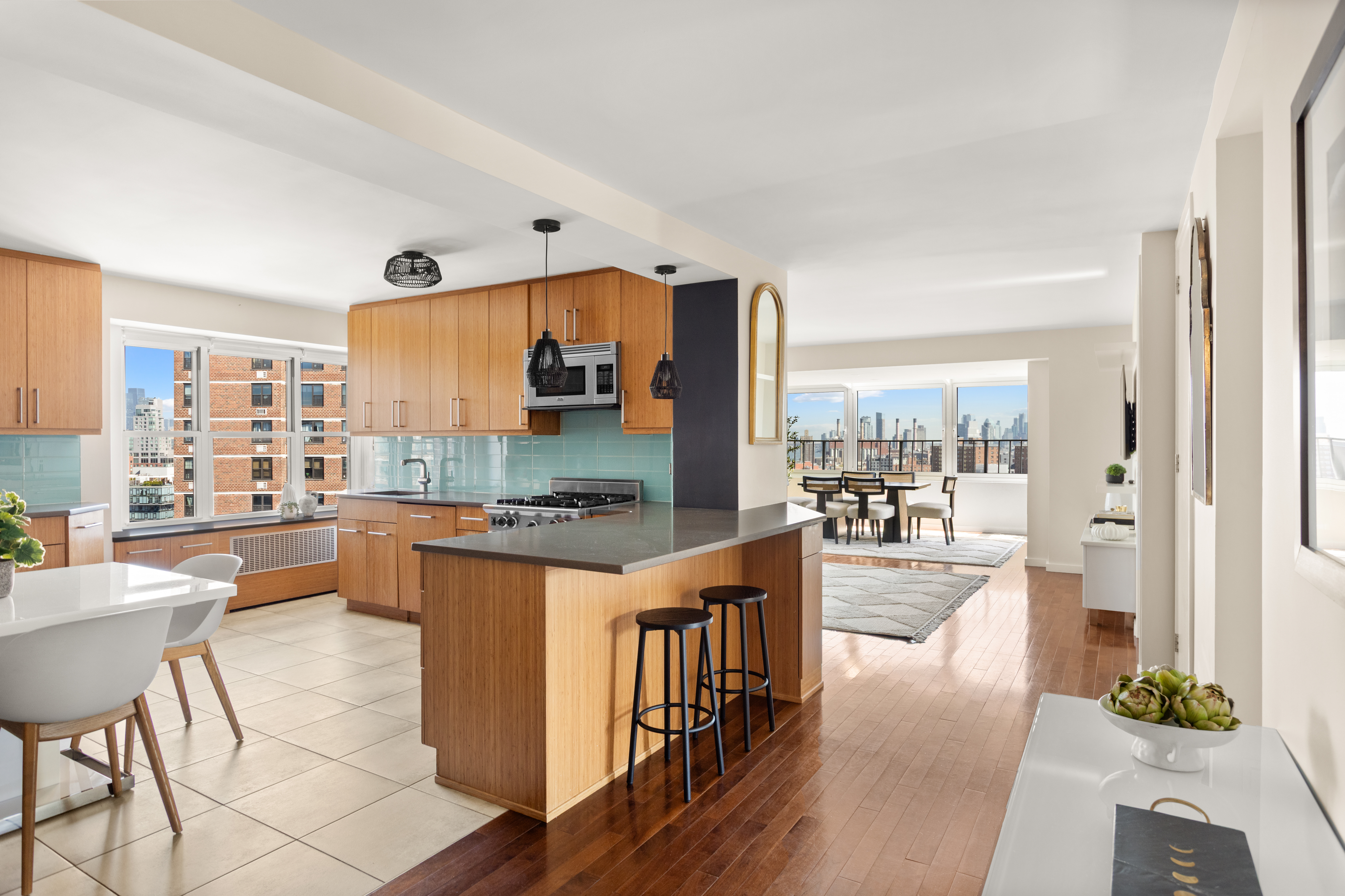 417 Grand Street, Unit D1801 Manhattan, NY 10002 - Photo 5 of 23 a large kitchen with stainless steel appliances a stove a refrigerator a dining table and chairs