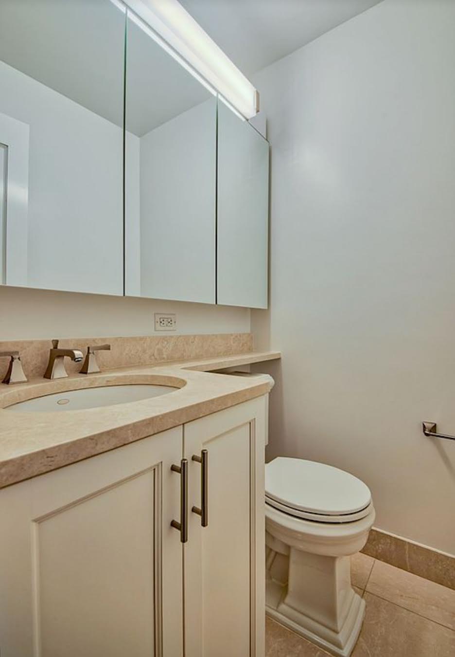 155 East 29th Street, Unit 7D Manhattan, NY 10016 - Photo 3 of 8 a bathroom with a toilet sink and mirror