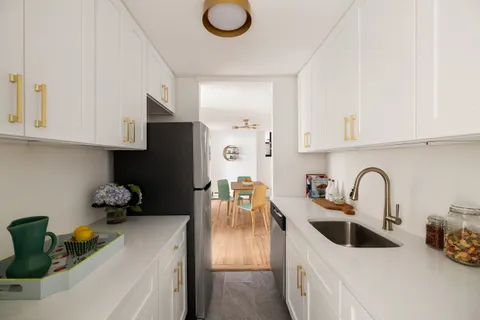a kitchen with stainless steel appliances granite countertop a sink a stove and a refrigerator
