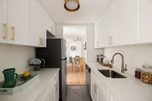 a kitchen with stainless steel appliances granite countertop a sink a stove and a refrigerator