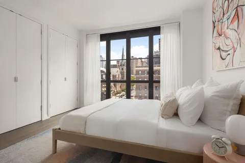 a large bed sitting in a bedroom next to a window