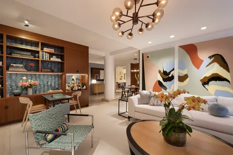 a living room with furniture a rug and white walls