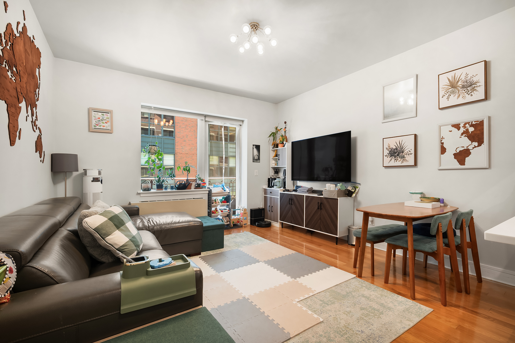 41-26 27th Street, Unit 5E Queens, NY 11101 - Photo 6 of 12 a living room with furniture and a flat screen tv