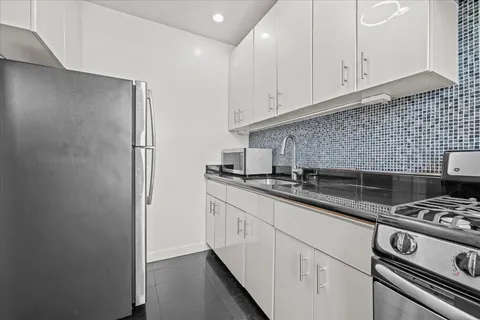 a kitchen with stainless steel appliances a sink stove and cabinets