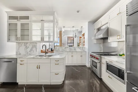 a kitchen with granite countertop white cabinets and white appliances
