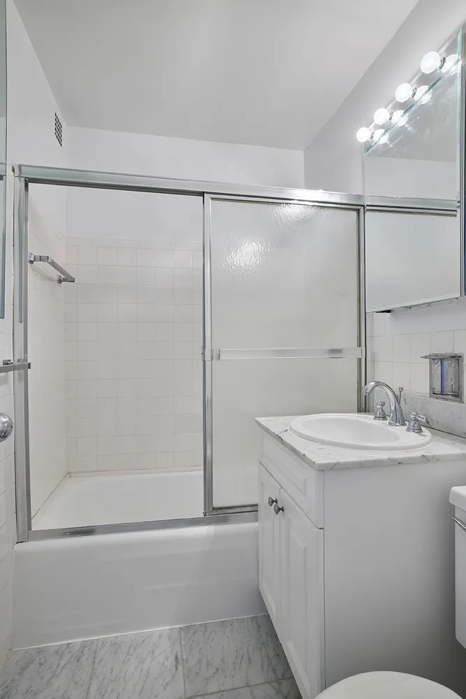 a bathroom with a shower sink vanity and mirror