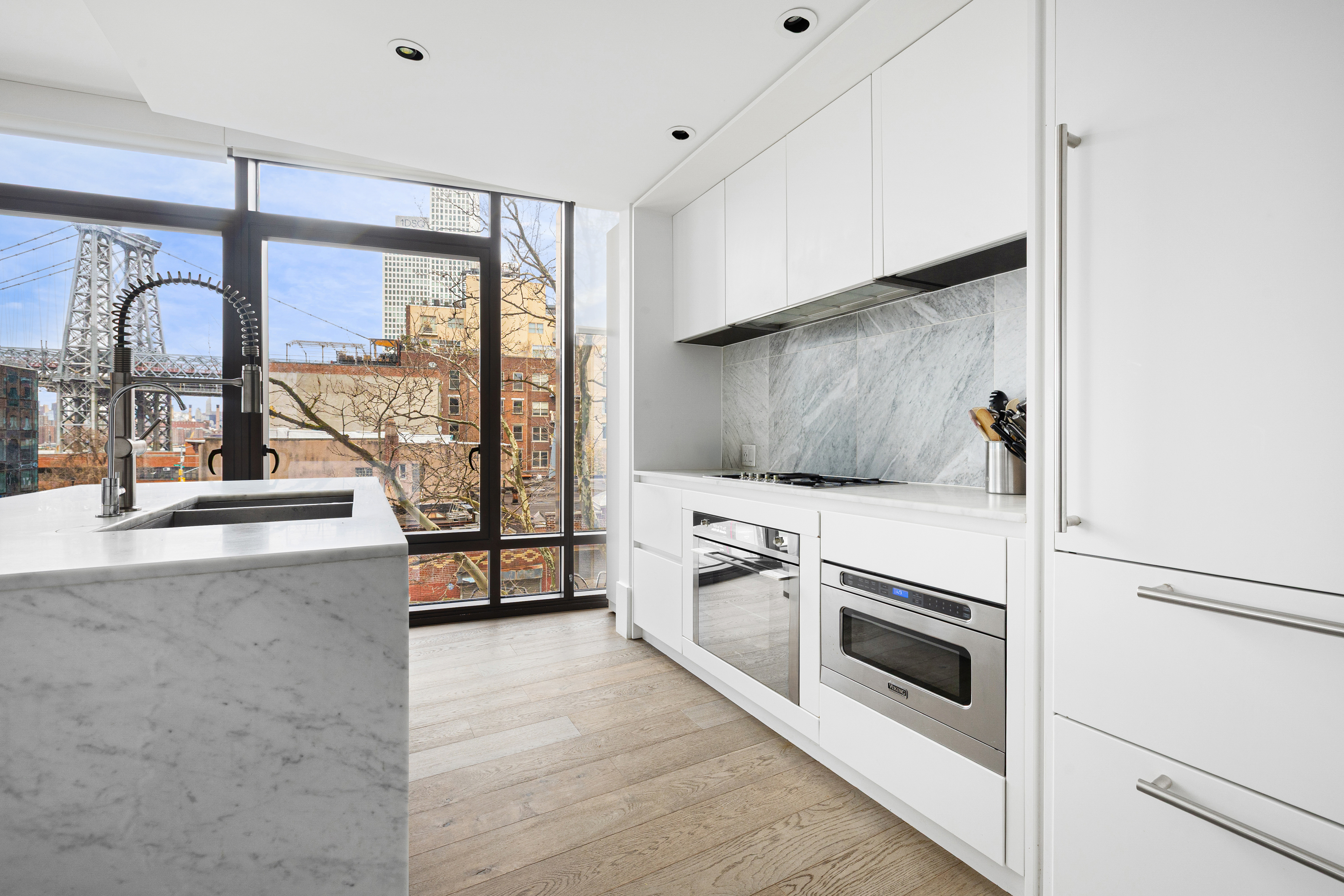 429 Kent Avenue, Unit 340 Brooklyn, NY 11249 - Photo 3 of 9 a view of a kitchen with a sink and a stove top oven