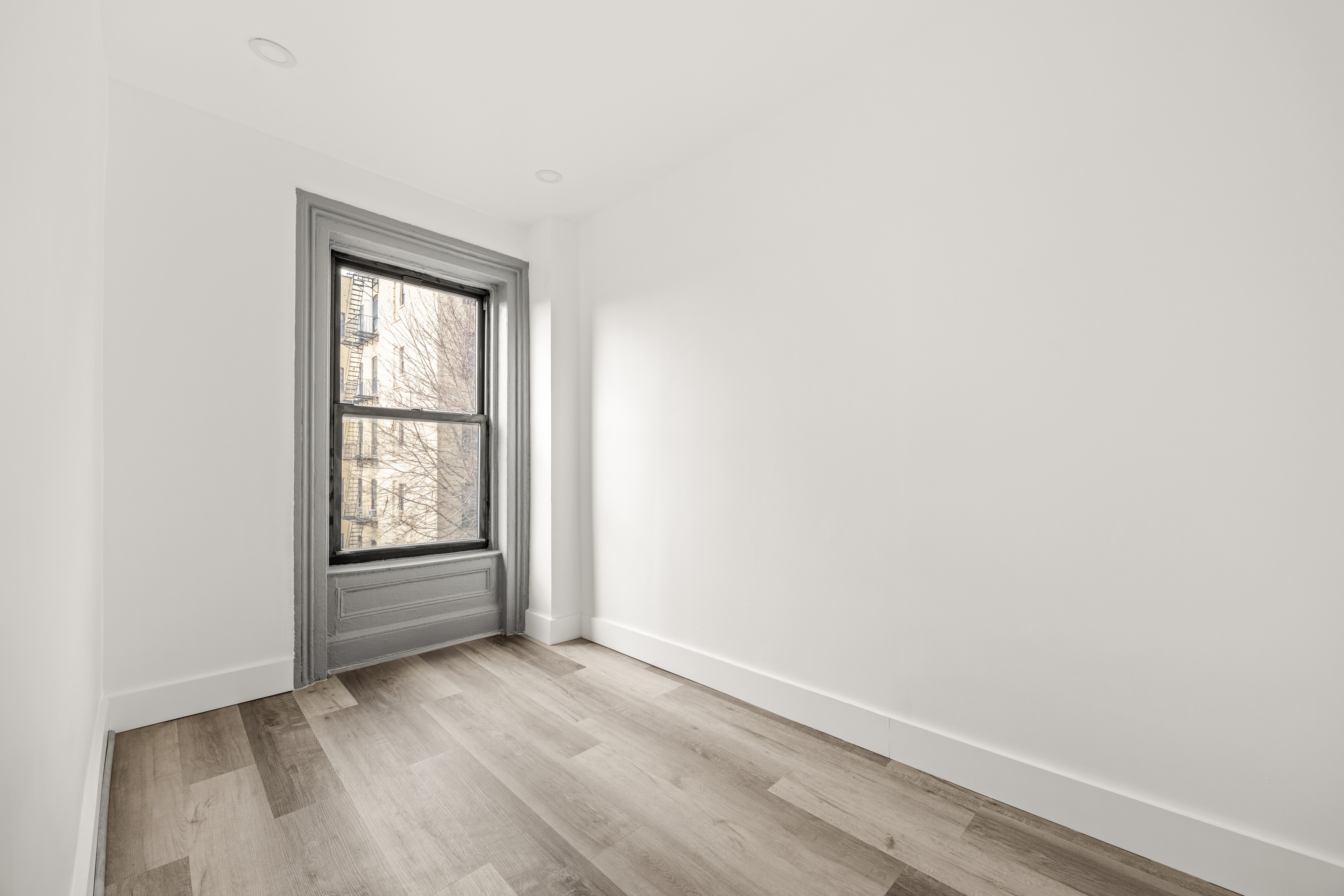 126 Quincy Street, Unit 3 Brooklyn, NY 11216 - Photo 8 of 11 an empty room with wooden floor and windows
