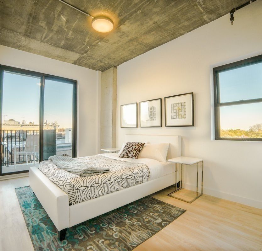 293 Hawthorne Street, Unit 2E Brooklyn, NY 11225 - Photo 4 of 21 a bedroom with a large bed and a chandelier