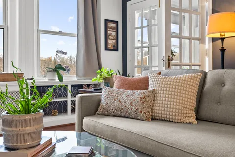a living room with fireplace furniture and a large window