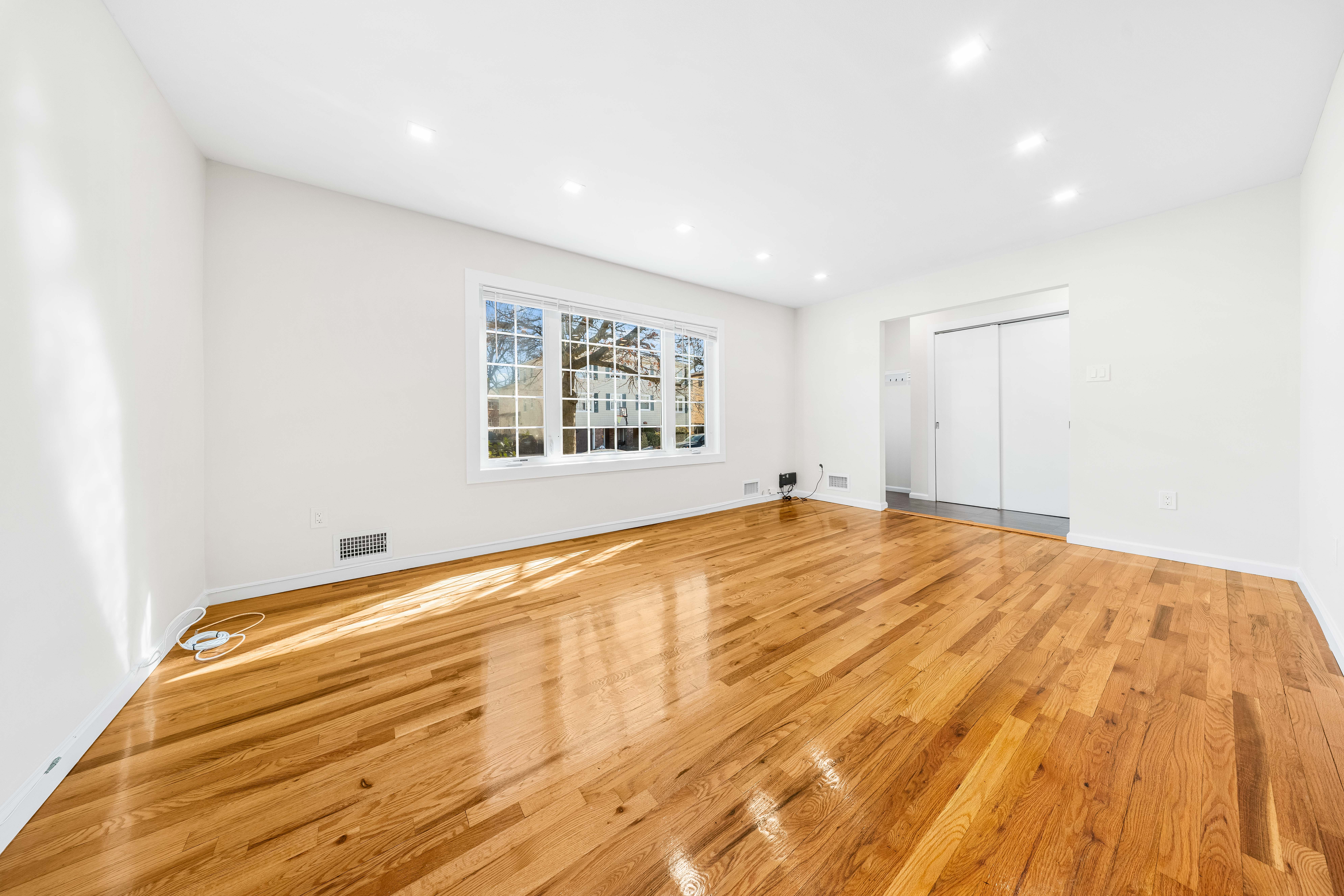 15-80 209th Street, Unit 2 Queens, NY 11360 - Photo 2 of 21 a view of empty room with wooden floor and fan
