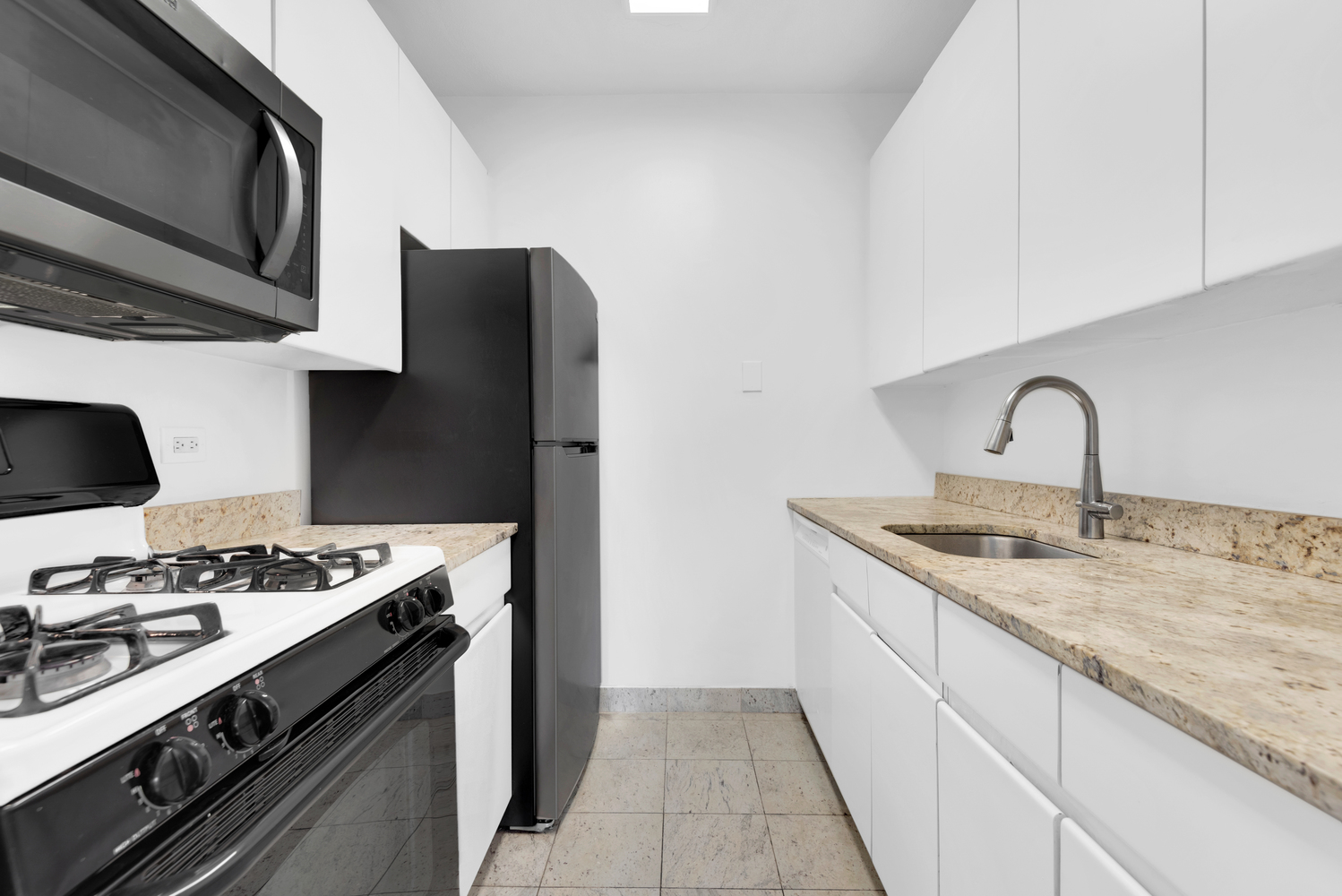 250 East 40th Street, Unit 22B Manhattan, NY 10016 - Photo 10 of 13 a kitchen with stainless steel appliances granite countertop a sink stove and refrigerator