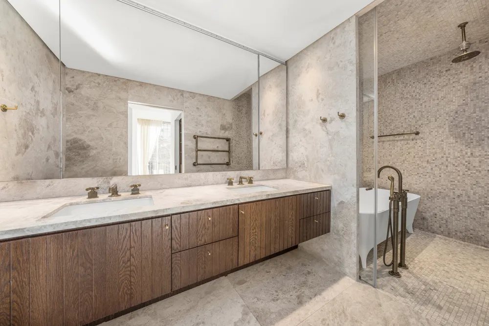 a spacious bathroom with a double vanity sink a mirror and a bathtub