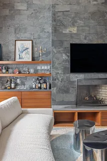 a living room with stainless steel appliances wooden floor and a fireplace