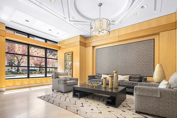 52 Park Avenue, Unit 5 Manhattan, NY 10016 - Photo 9 of 12 a living room with furniture and a chandelier