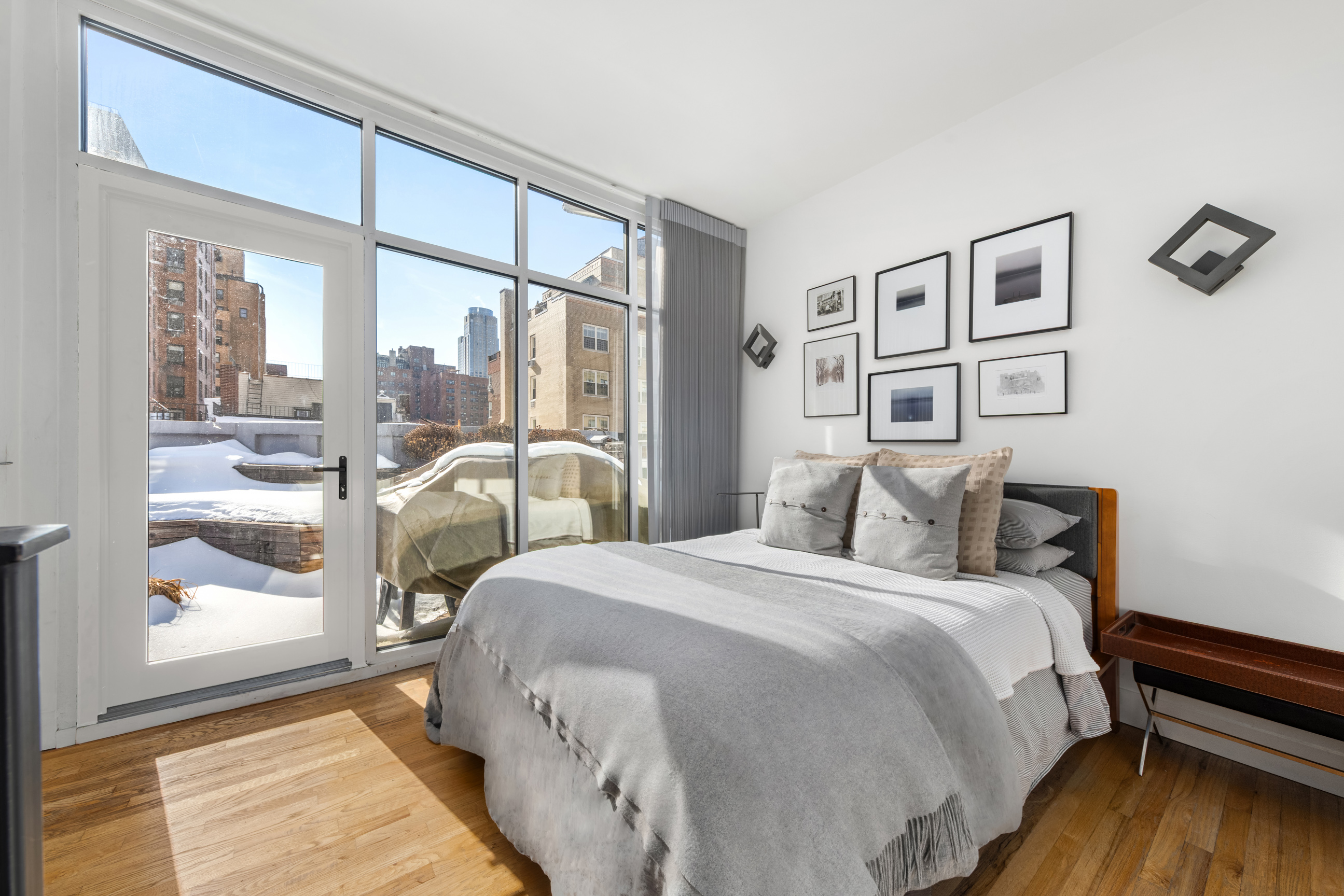 311 West 76th Street, Unit PH-5 Manhattan, NY 10023 - Photo 4 of 11 a bedroom with a bed and a large window with outer view