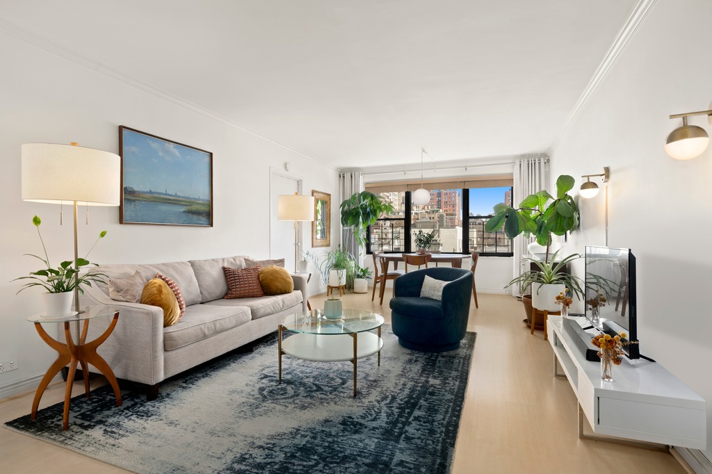 a living room with furniture a flat screen tv and a large window