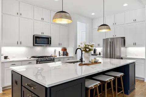 a kitchen with kitchen island granite countertop a sink a center island and cabinets