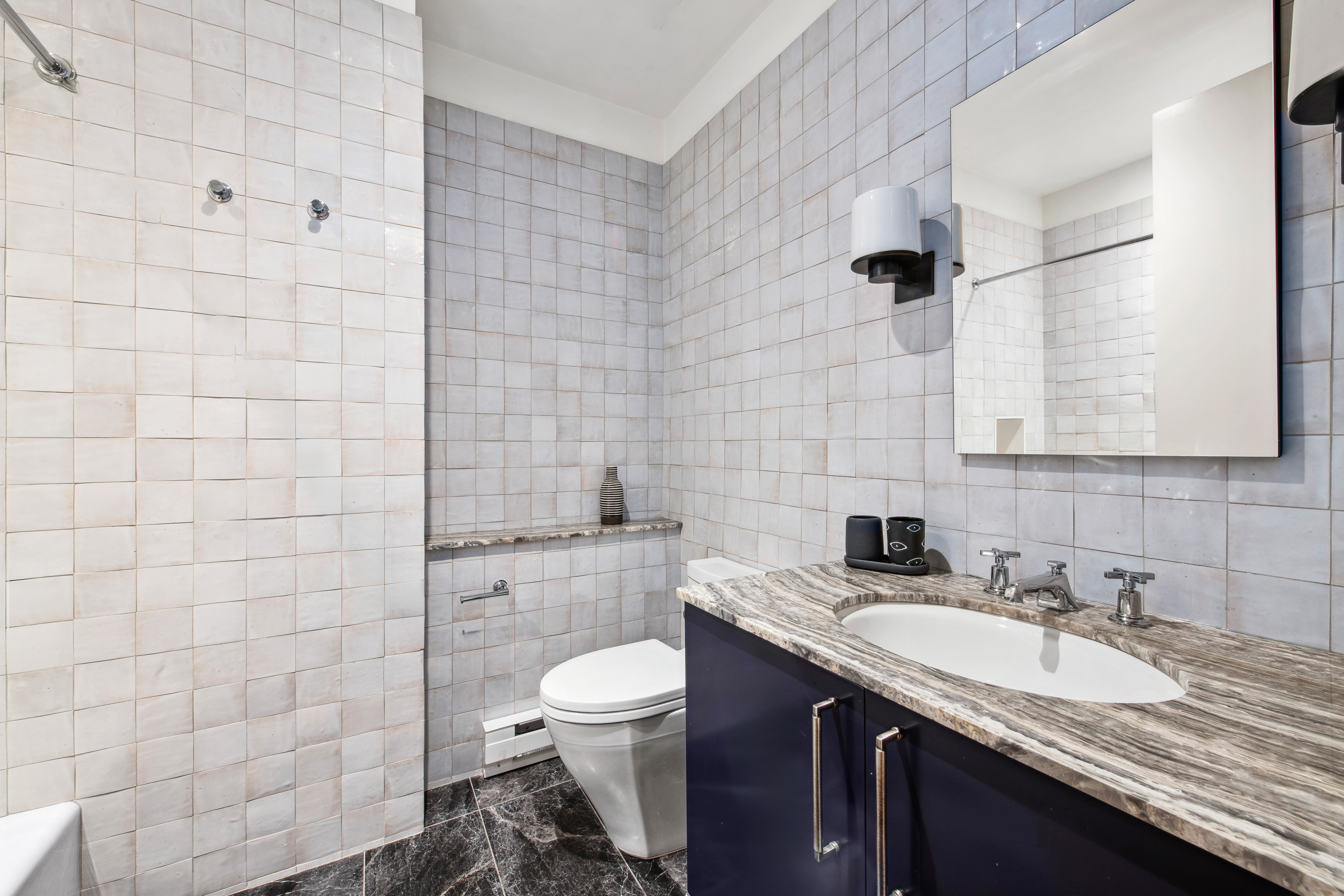 150 Nassau Street, Unit 10A Manhattan, NY 10038 - Photo 10 of 20 a bathroom with a granite countertop sink a toilet and a mirror