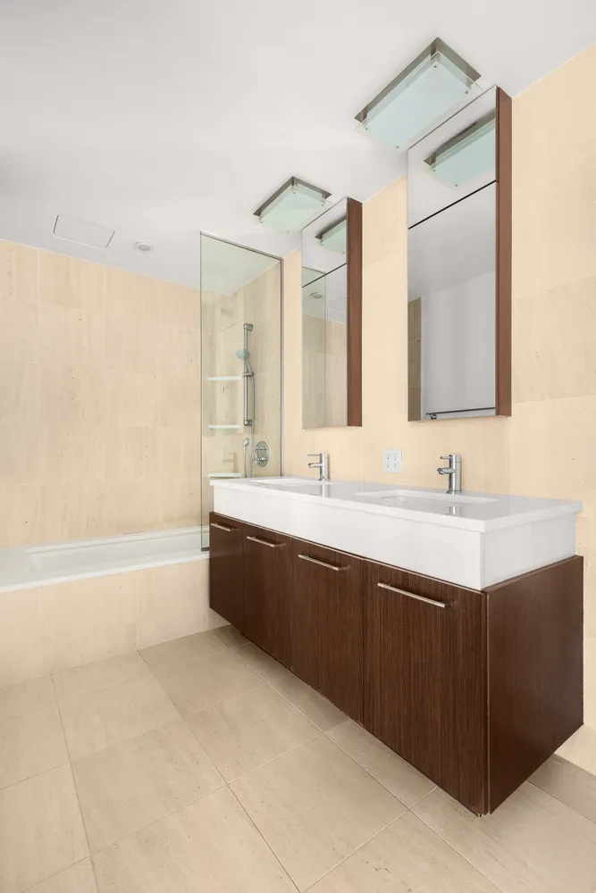 a bathroom with a tub a sink and mirror