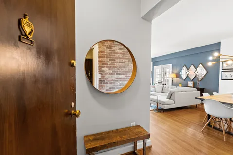 a living room with couches and a bookshelf with wooden floor