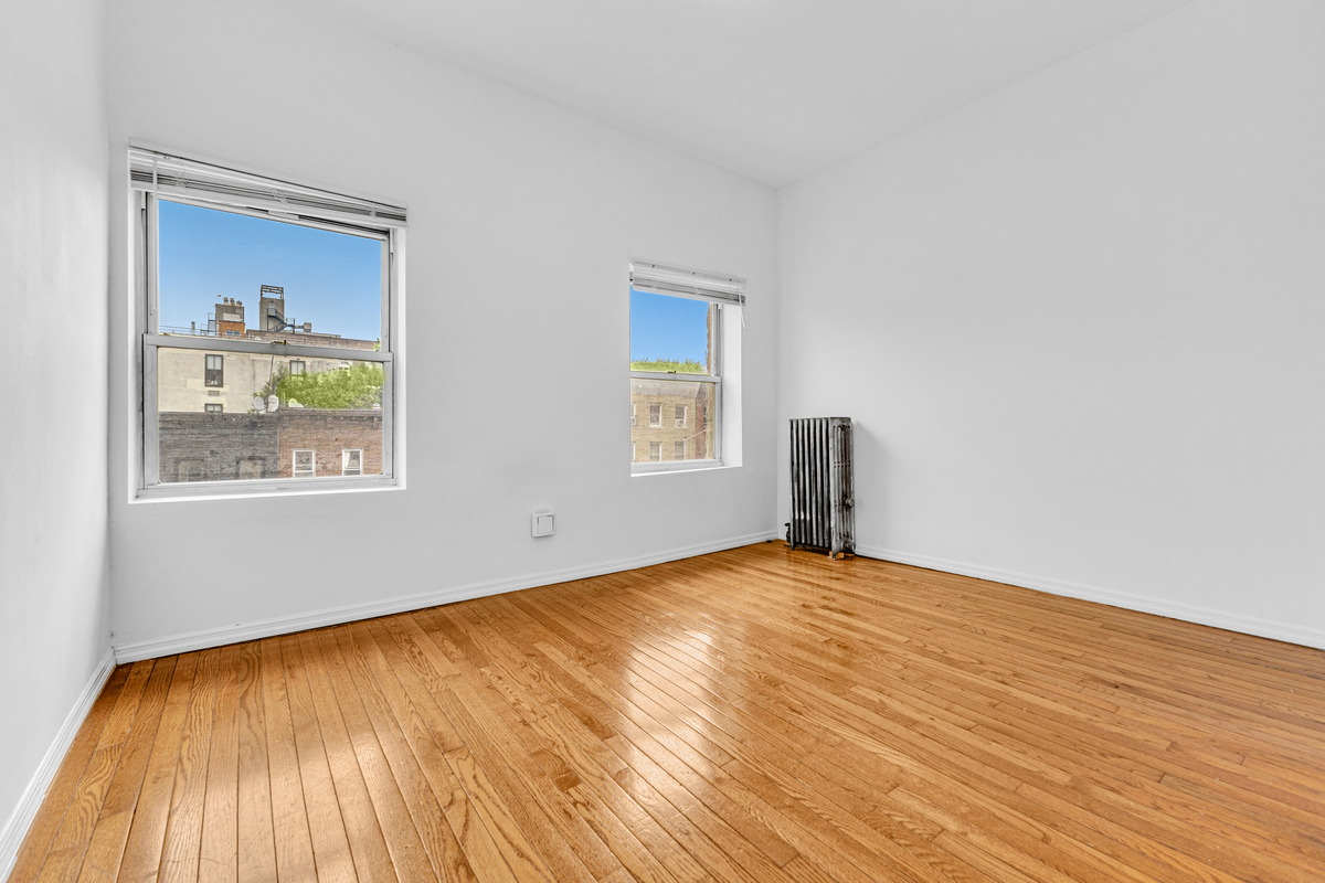 116 Ryerson Street Brooklyn, NY 11205 - Photo 4 of 16 a view of an empty room with window and wooden floor