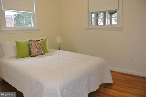 a large bed sitting in a bedroom next to a window