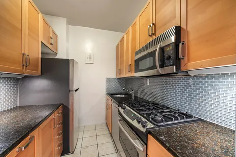 a kitchen with stainless steel appliances granite countertop a stove a microwave and a refrigerator