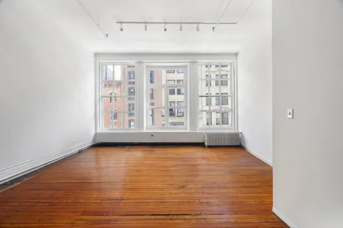 a view of a room with wooden floor and window
