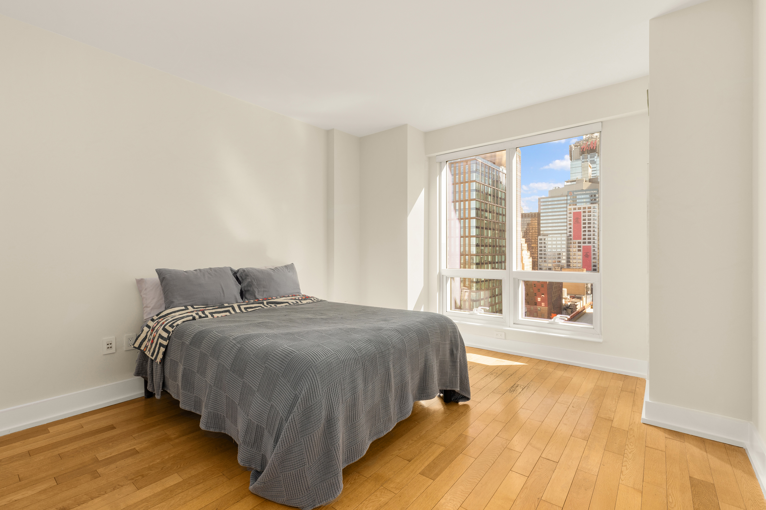 350 West 42nd Street, Unit 26G Manhattan, NY 10036 - Photo 9 of 11 a spacious bedroom with a bed and wooden floor