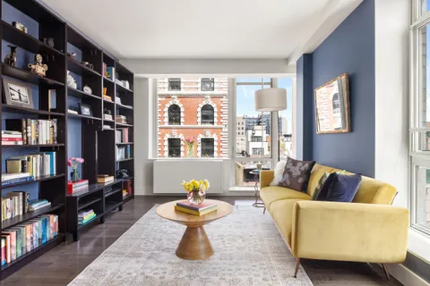 a living room with furniture and a book shelf