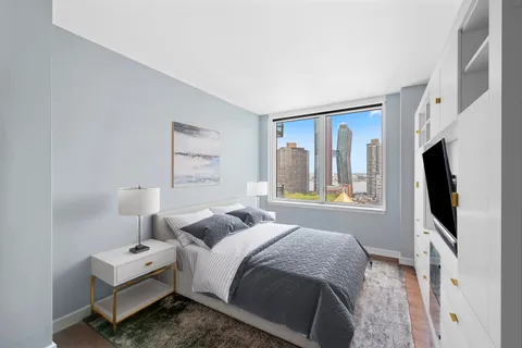 a bedroom with a bed tv and window