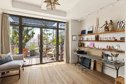 a view of a workspace with furniture and a window