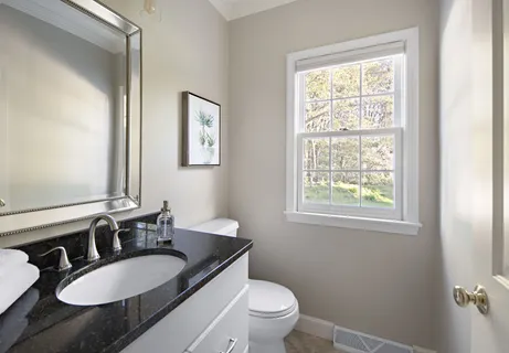 a bathroom with a granite countertop toilet a sink and a mirror