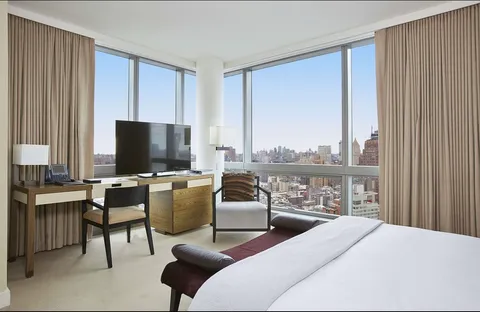 a bedroom with a bed and large window