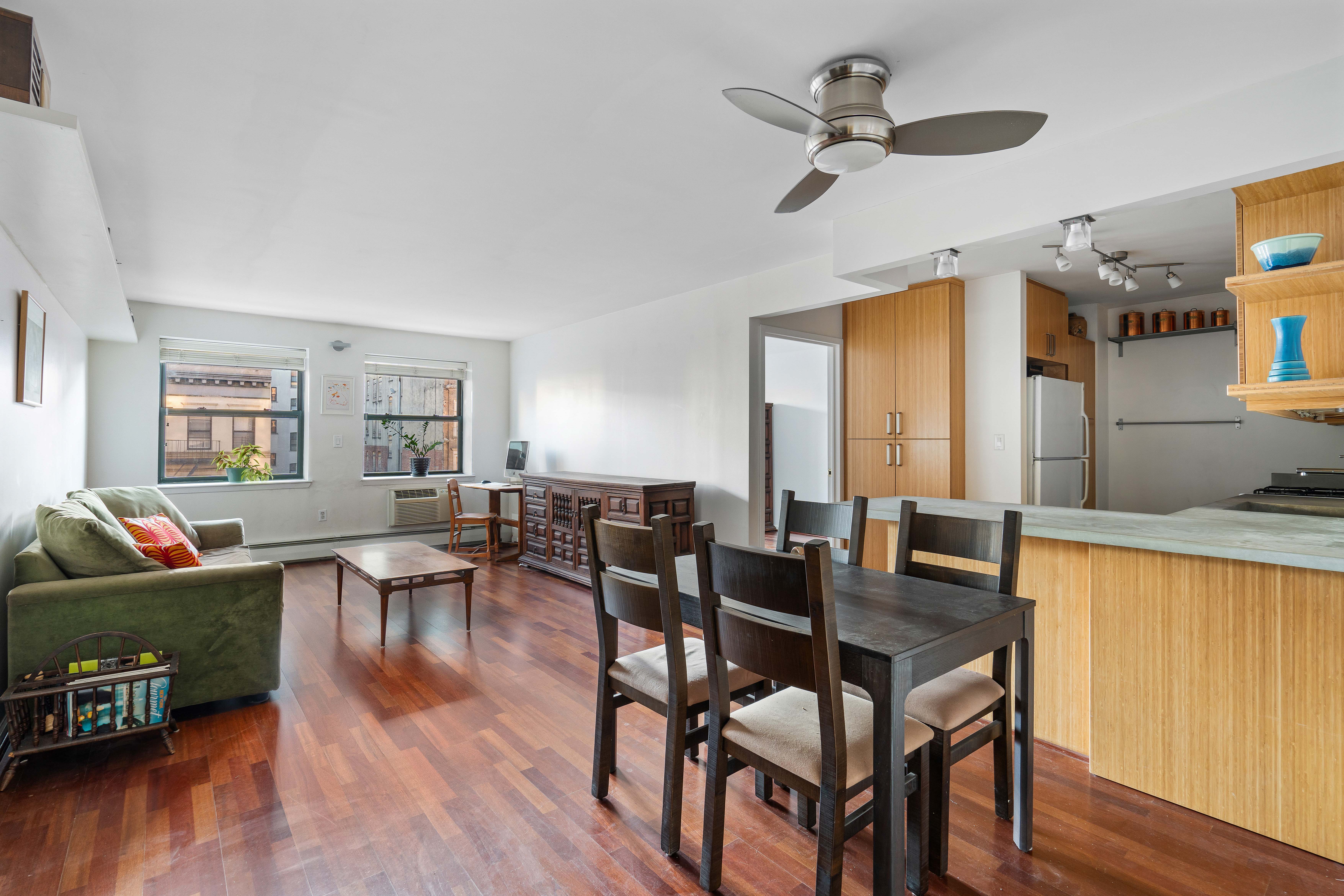 130 Lenox Avenue, Unit 522 Manhattan, NY 10026 - Photo 1 of 7 a dining room with wooden floor a chandelier fan a wooden table and chairs