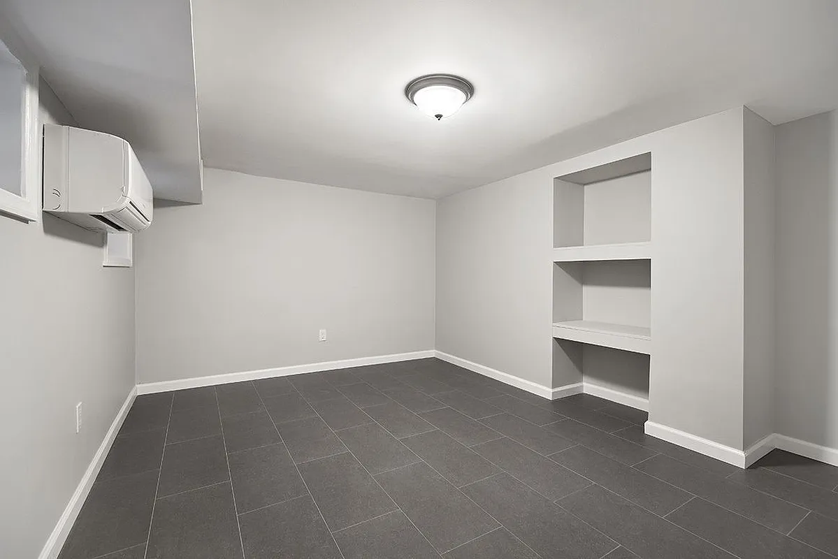 306 7th Street, Unit 1 Brooklyn, NY 11215 - Photo 7 of 9 a view of an empty room with cabinet and a window