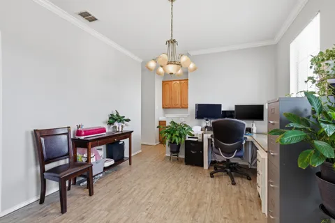 a workspace with furniture a potted plant and wooden floor