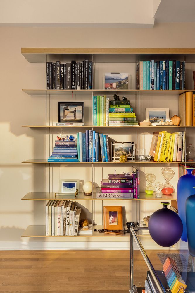 a room with lots of books and a dining table